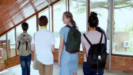 Portrait-of-happy-students-standing-in-corridor