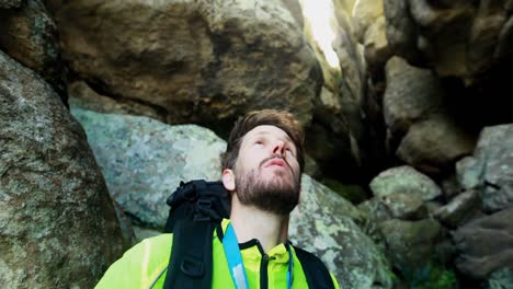 male hiker exploring a cave 4k