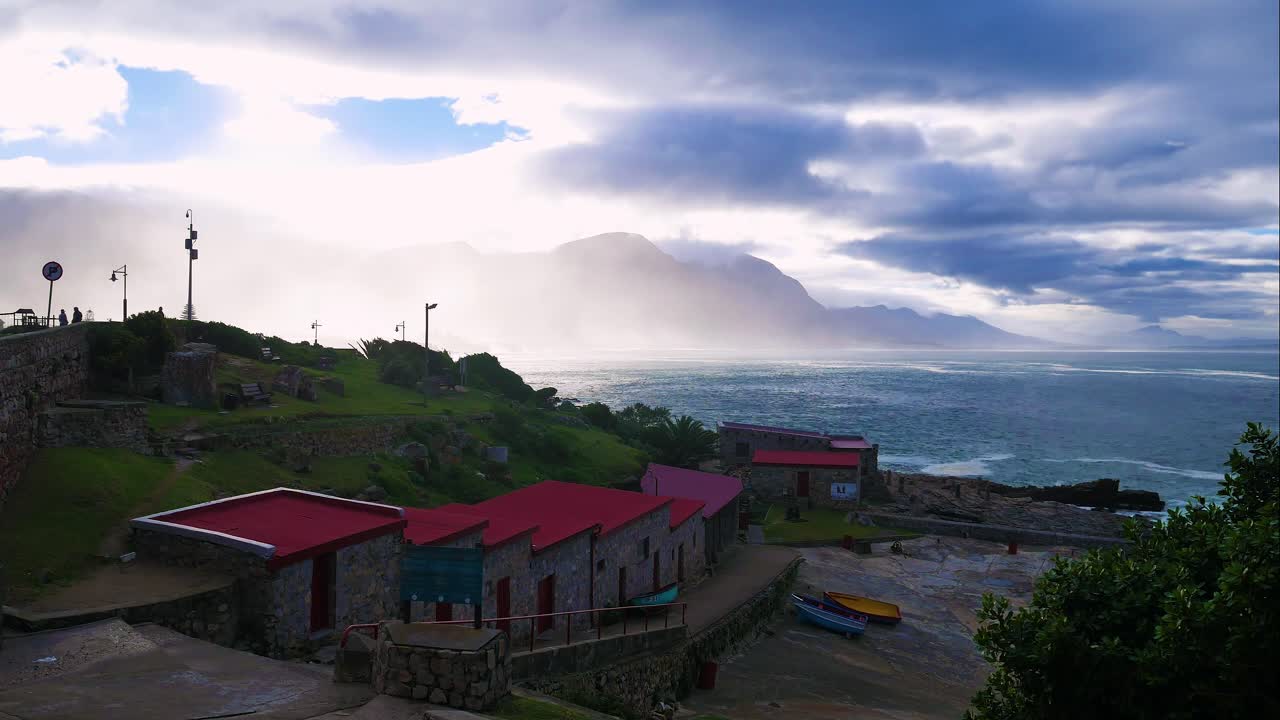lapso de tiempo de nubes moviéndose sobre la montaña, visto desde el histórico puerto viejo en hermanus, sudáfrica