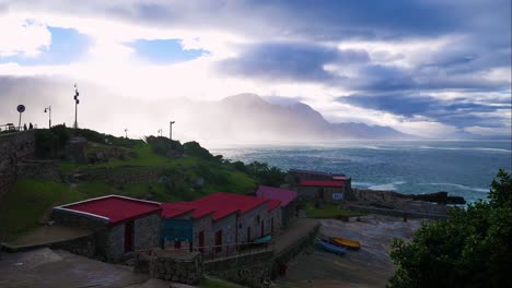 Timelapse-of-clouds-moving-over-mountain,-viewed-from-historic-old-harbour-in-Hermanus,-South-Africa