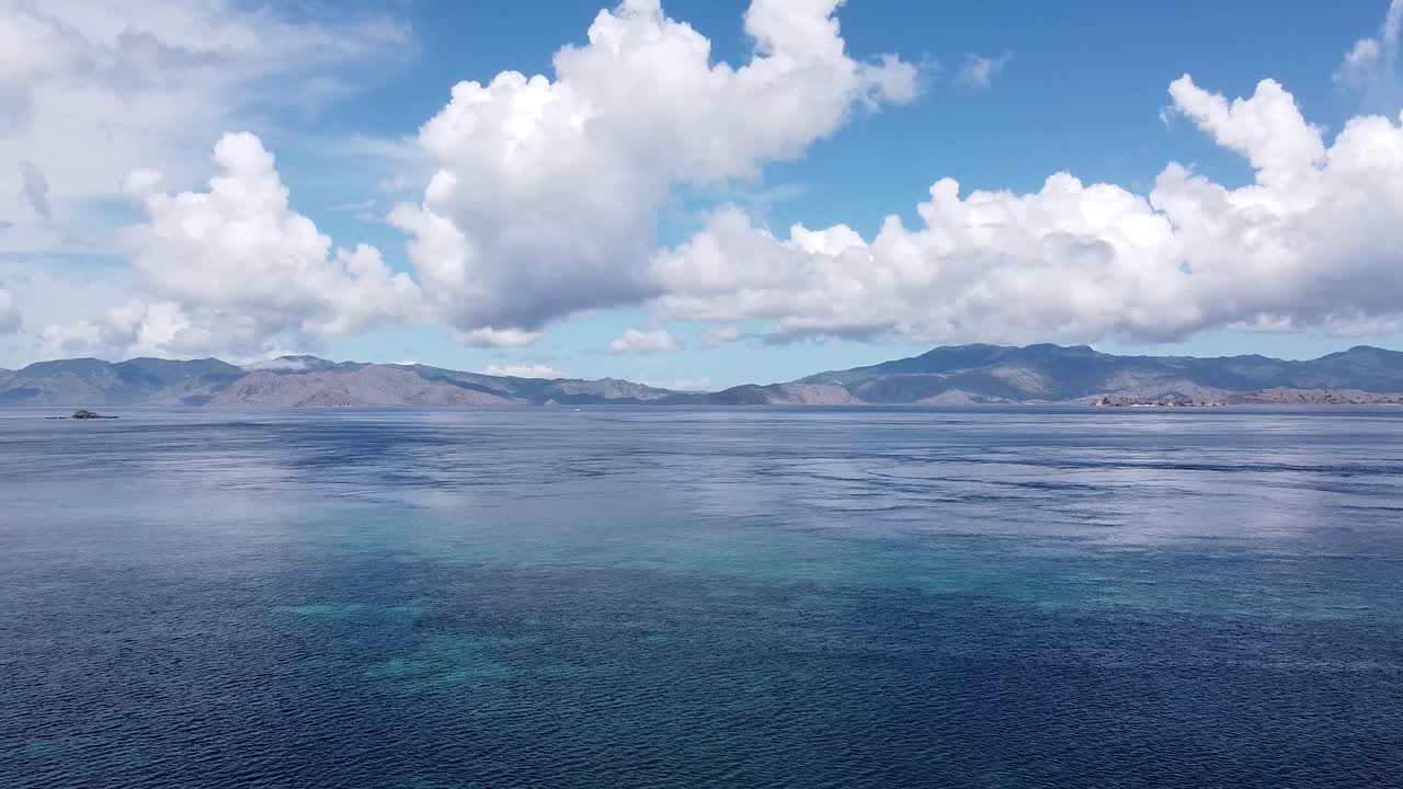 푸른 물 과 구름 과 멀리 있는 산 들 이 있는 열대 해양 의 공중 풍경