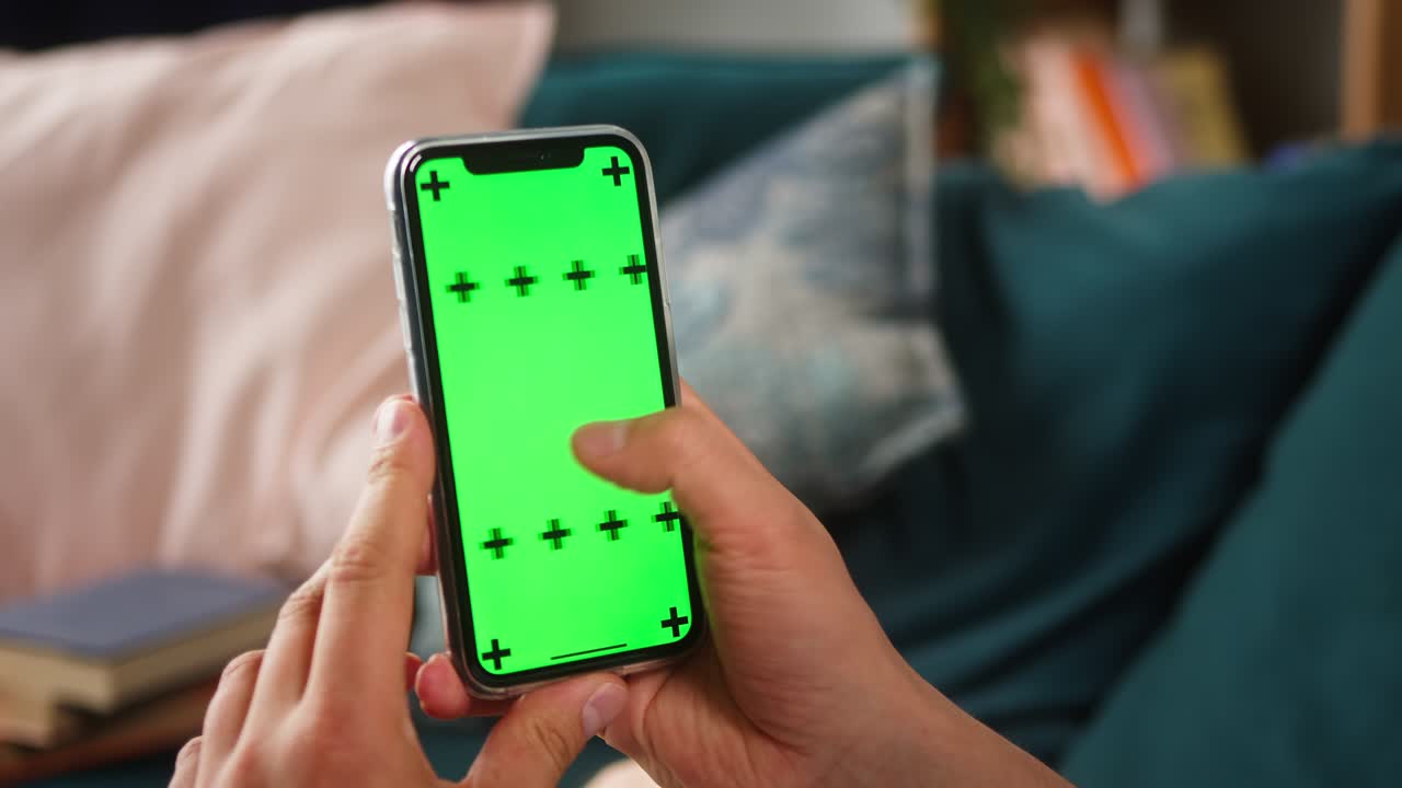 primer plano de un teléfono inteligente con pantalla verde, manos de un joven sosteniendo un teléfono móvil, zoom in, pantalla aislada, pantalla táctil, concepto de teléfono de tecla cromática, navegar por internet con aparatos