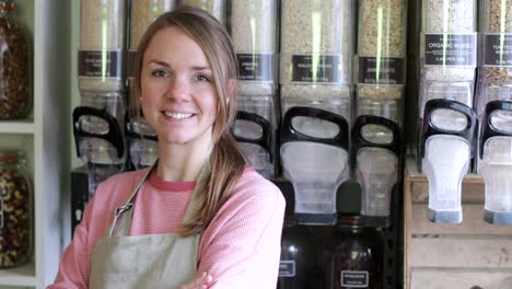 portrait of female owner of sustainable plastic free grocery store standing in front of shelves