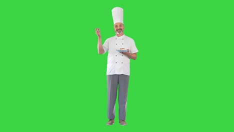 chef barbudo haciendo un delicioso gesto con el postre en sus manos en una pantalla verde, llave de croma