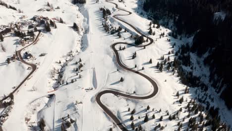 drone shot along beautiful winding mountain road along side a ski slope