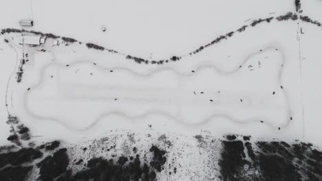 high aerial top down view of snowy drift event race track full circle with turns