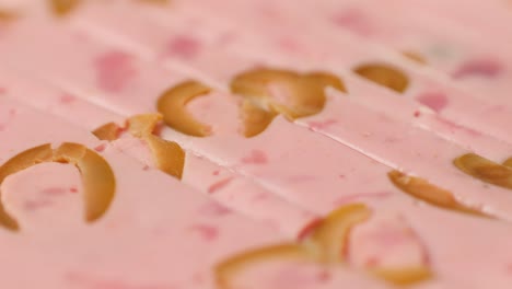 ham italian mordatella, man slices of traditional italian antipasti mortadella sausage on a wooden cutting board, close up macro of chicken or turkey jamon, fat breakfast dish.