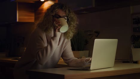 video of woman drinking coffee and working ah home