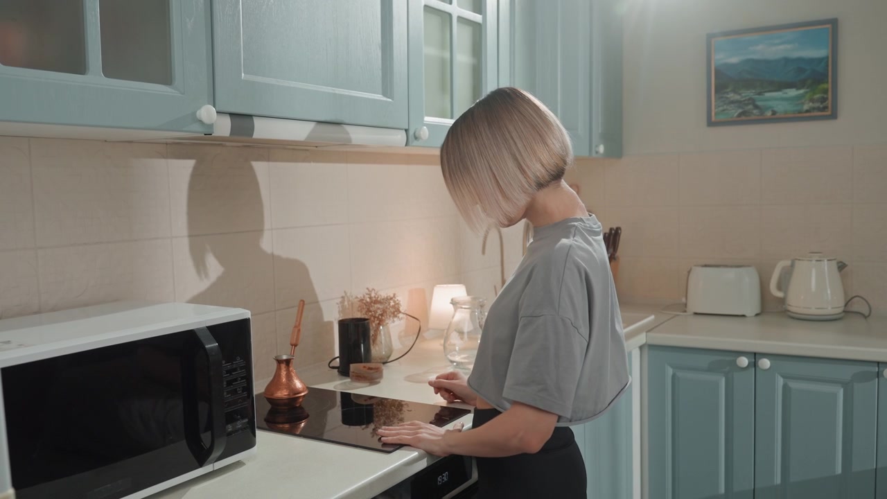 Scena di cucina accogliente con preparazione rilassata del caffè. Cucina luminosa dove una donna prepara tranquillamente l'espresso mattutino. Scena serena di donna che prepara il caffè in un ambiente cucina caldo e invitante.