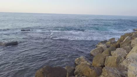 fascinante primer plano del rompeolas rocoso en jaffa mientras las olas golpean suavemente los bordes