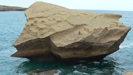 Lonely-volcanic-rock-near-coastline-of-Tenerife,-handheld