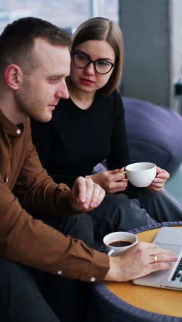 two smiling creative workers discussing project during meeting in cafe vertical video