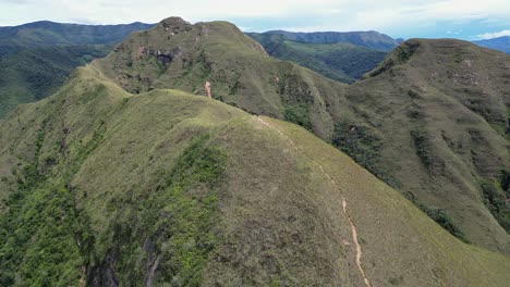 aerial descends to lone hiker on summit ridge trail, codo de los andes