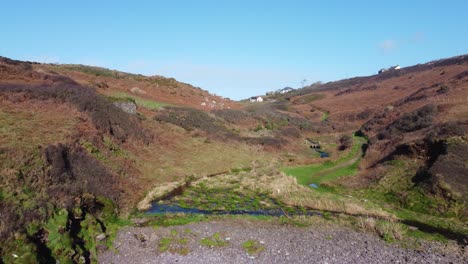 Kleines-Tal-Mit-Verstreuten-Häusern-Und-Einem-Fluss,-Der-Zu-Einem-Felsigen-Strand-Führt