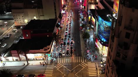 aerial at night over hollywood boulevard and highland intersection streets towards el capitan theatre, traffic of cars