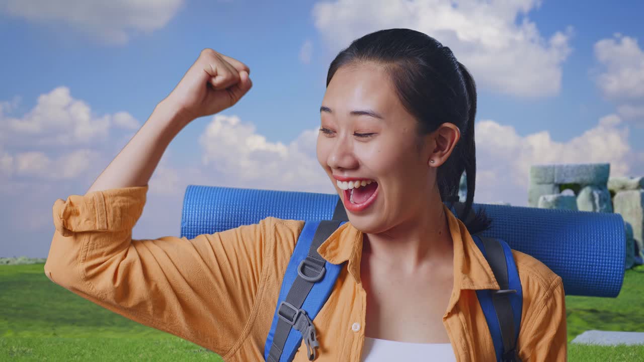 Close Up Of Asian Female Hiker With Mountaineering Backpack Smiling And Flexing Her Bicep While Traveling In Stonehenge