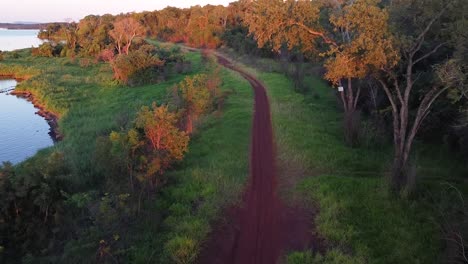 Sendero-Corriendo-Junto-Al-Agua-Y-Los-árboles-Al-Atardecer