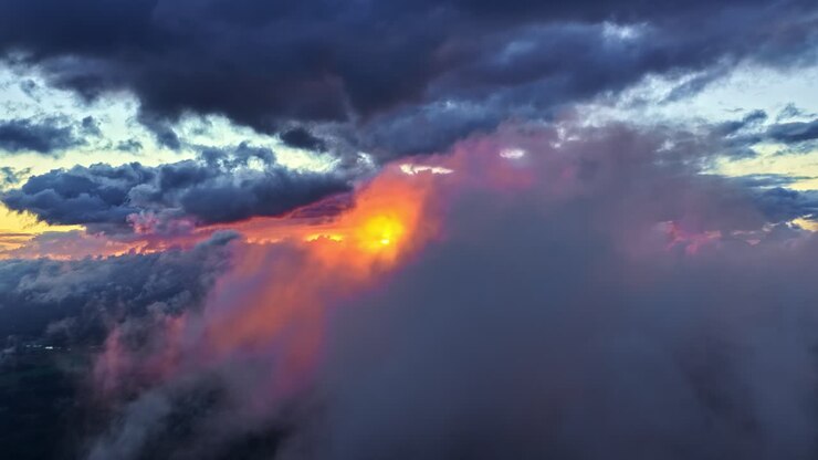 Aerial: sea of fog above the clouds in high altitude at sunset with golden hour colors, dolly out drone shot