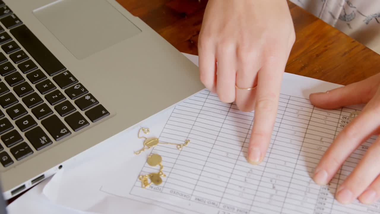 보석 디자이너가 워크 ⁇  4k에서 기록을 검사하고 있습니다.