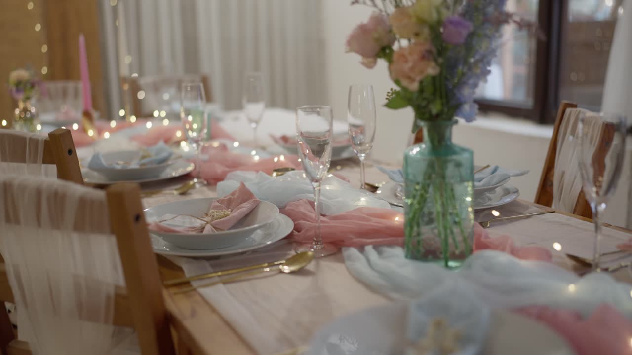 Close-up shot of a decorated and prepared wedding reception table. Luxury tableware, glasses, candles, and fabrics