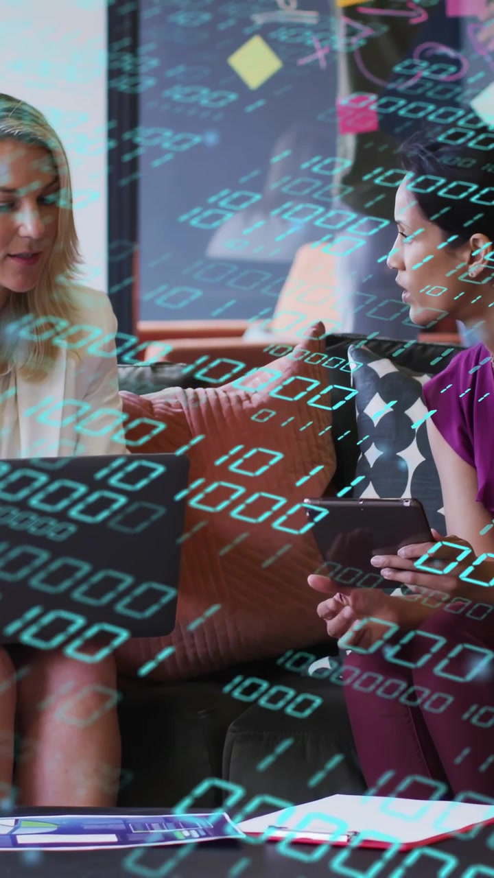 Video verticale: Due donne sul divano che guardano schermi, una inclina e tocca un tablet, con dettagli tecnologici in tonalità verde acqua.