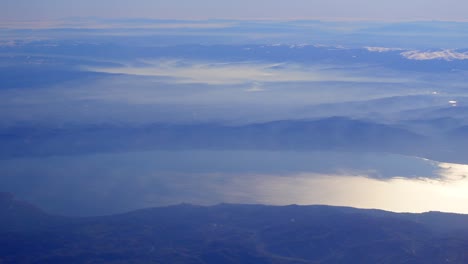 aerial view of misty mountains and lake