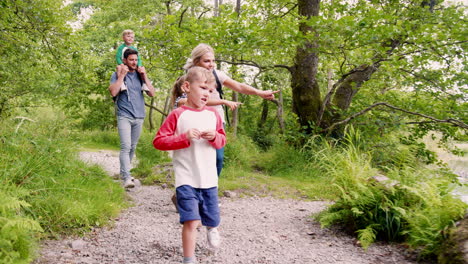 slow motion shot of family hiking along path by river in uk lake district