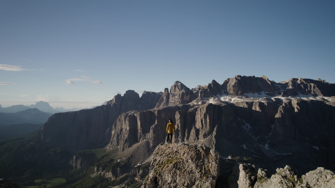 alpinista en un acantilado en un mirador épico sobre los dolomitas italianos