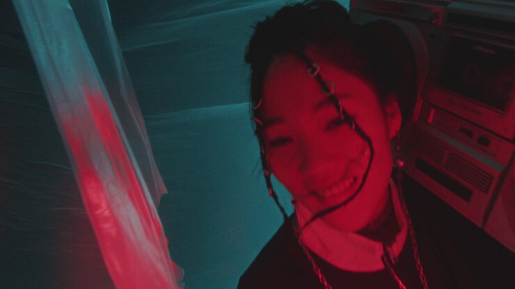 Cheerful Asian Girl in 90s Outfit Holding Boombox and Dancing in Neon Light
