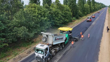 aerial view of roadworks on the road. heavy machinery laying new asphalt on the highway in a summertime. asphalt road construction.