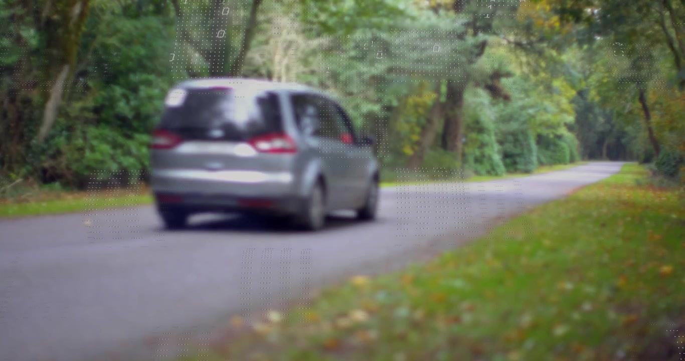 Minivan che entra nell'inquadratura su strada, creando una sovrapposizione binaria punteggiata che mostra dati tecnologici, che si spostano e svaniscono.