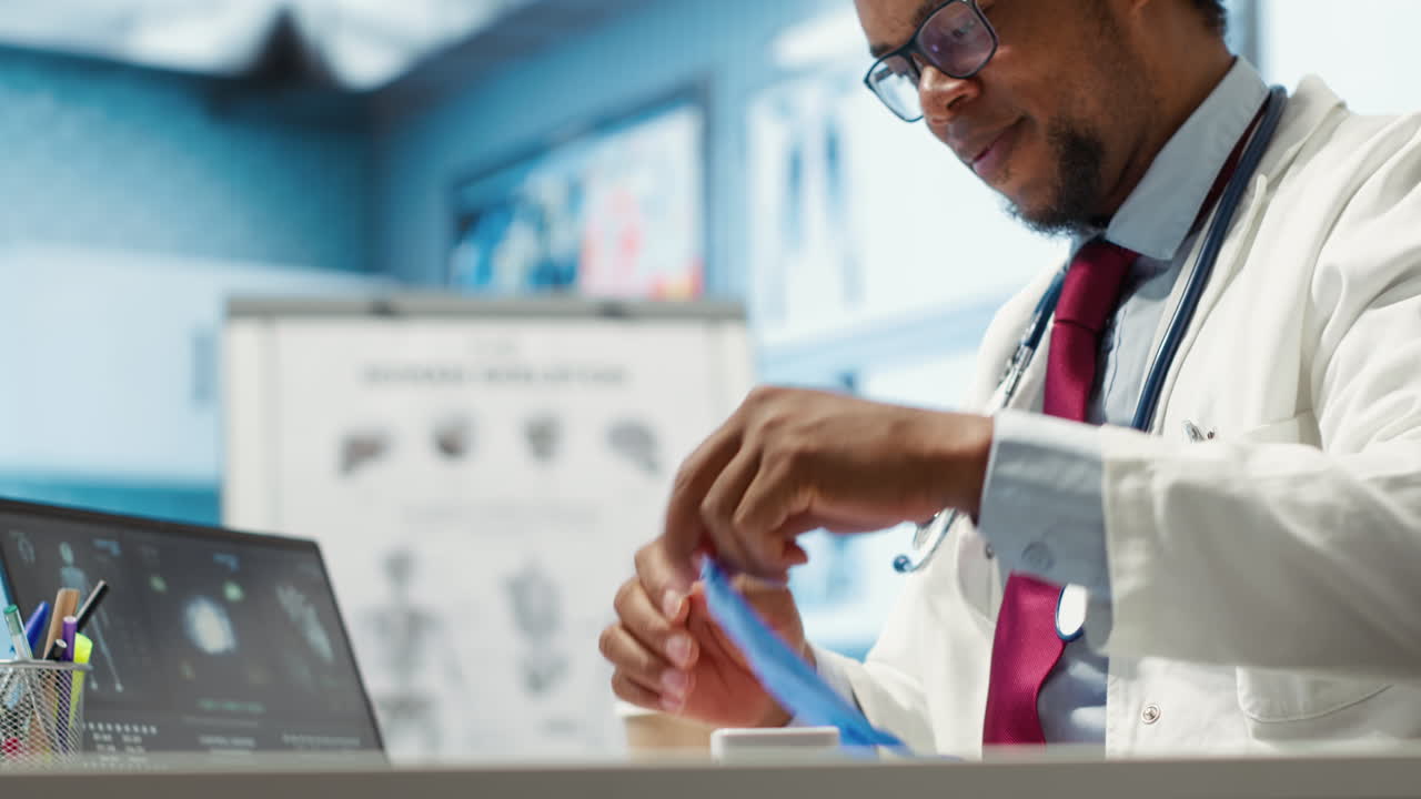 General practitioner putting his medical disposable gloves on before examining