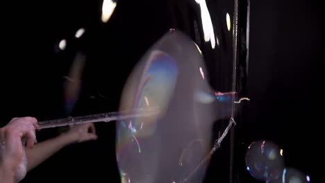 close-up: pretty girl does tricks with soap bubbles. she blows a lot of small bubbles, releases smoke