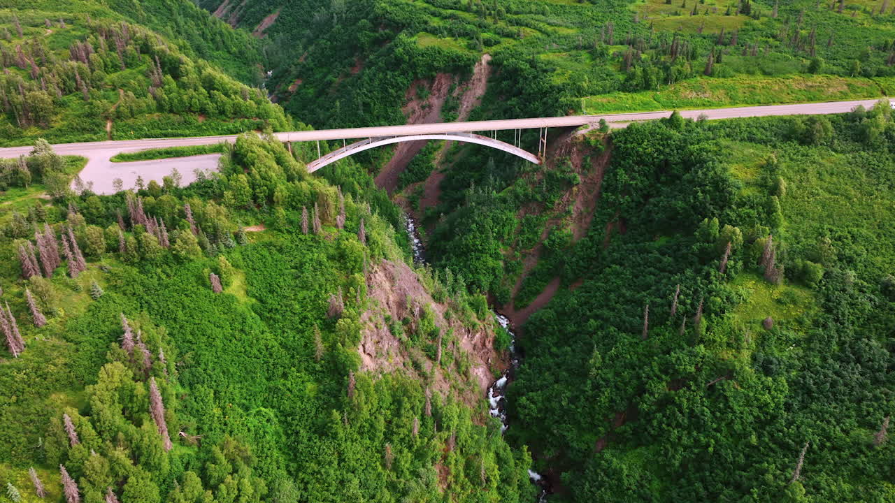 Alaska stunning landscapes. Aerial view of a stunning green valley in Alaska featuring a bridge and flowing river, capturing the essence of nature