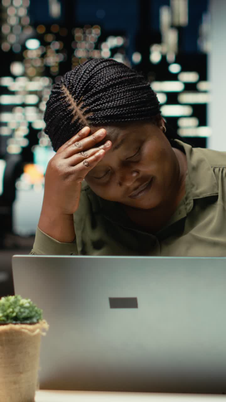 Vertical Video Troubled overworked woman sighing after realizing the late hour