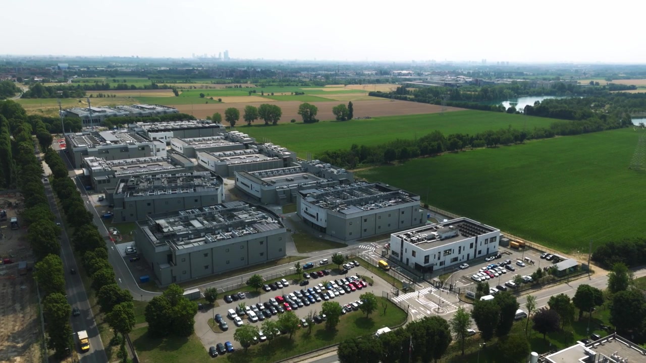 Large modern data center campus with multiple buildings and cooling systems on the roof, located on the outskirts of milan, italy