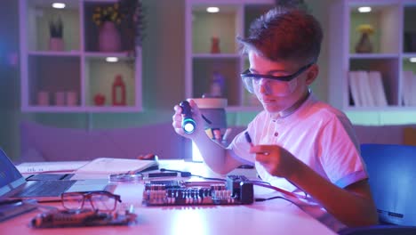 the little boy examines the piece of technological computer and tries to understand it.