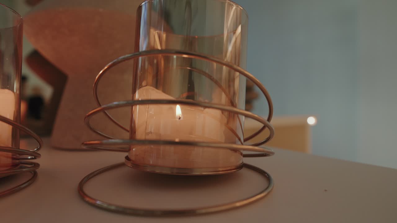 close up of candle flame glowing in artistic wire candle holder