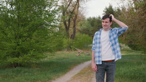 man walking in a forest path