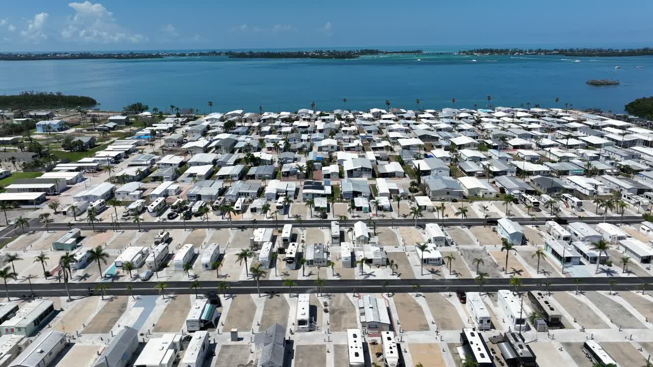 Aerial lateral shot of interconnected homes along coastline. Tranquil waters of Cortez neighborhood in summer. Florida,USA. Serene landscape atmosphere in America.
