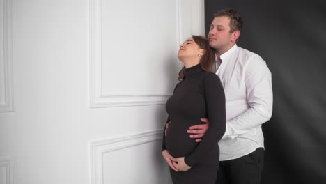 una giovane donna incinta con il marito che aspetta un bambino. la giovane famiglia sta aspettando il rifornimento. una felice donna in gravidanza con la pancia grande che si riposa a casa. una giovane madre incinta carezza la sua pancia.