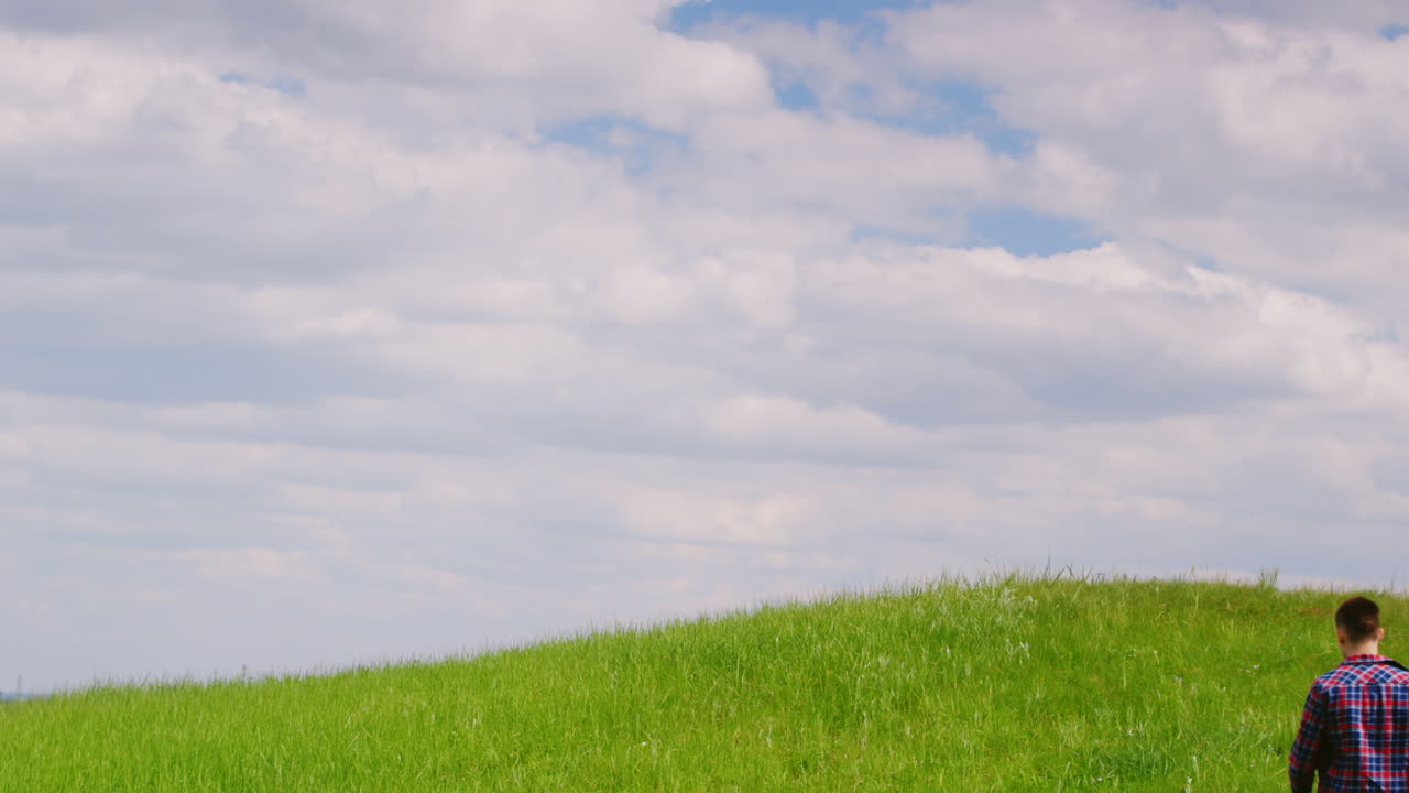 한 무리의 아이들 - 두 명의 십대 소년과 여섯 살 된 소녀가 함께 녹색 언덕을 오르고 있습니다