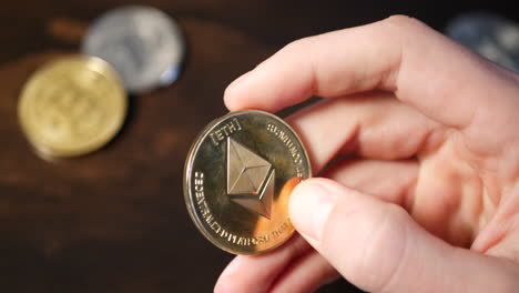 un hombre que sostiene una moneda ethereum de criptomoneda digital mientras piensa en una economía segura y descentralizada y el valor financiero de su inversión arriesgada en criptografía
