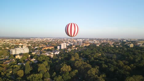 Toma-Aérea-En-órbita-De-Un-Drone-En-Globo-Rojo-Y-Blanco-En-El-Parque-De-La-Ciudad-De-Budapest