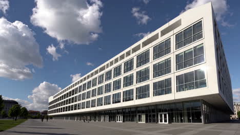 modern white building with glass facade under blue sky