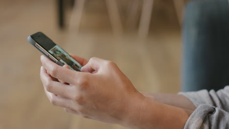 Close-up-of-Woman's-flipping-through-vacation-photos-on-smart-phone-at-home