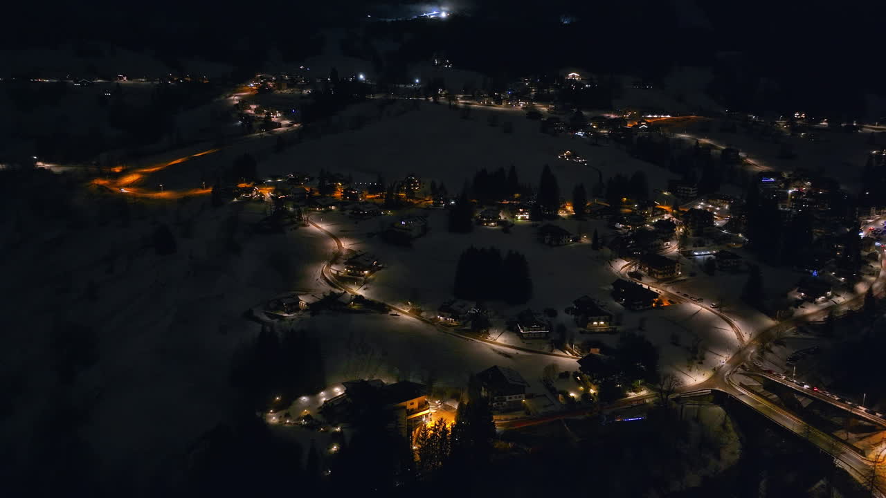 Aerial drone view of the buildings in the Cortina d'Ampezzo town in the Dolomites, Italy at night