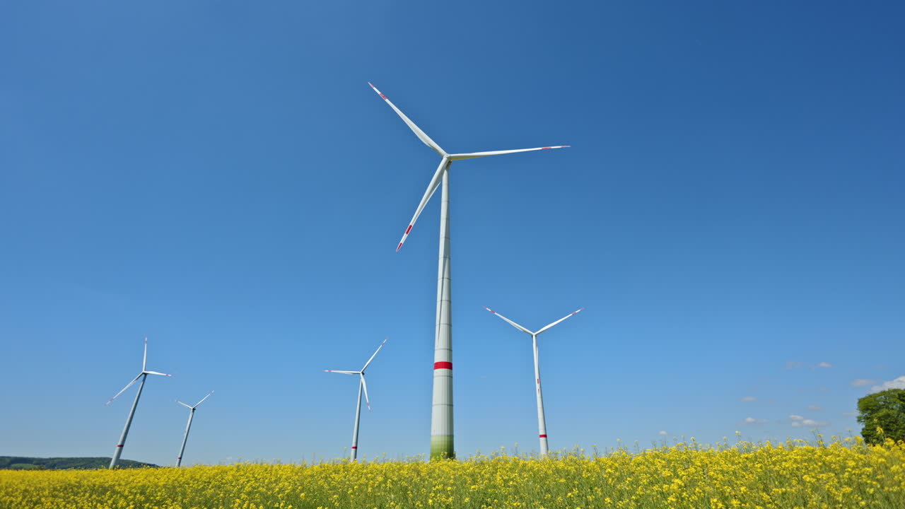 Wind turbine field in green field. Wind farm with blue sky and green agricultural field, also wind turbine park in Europe
