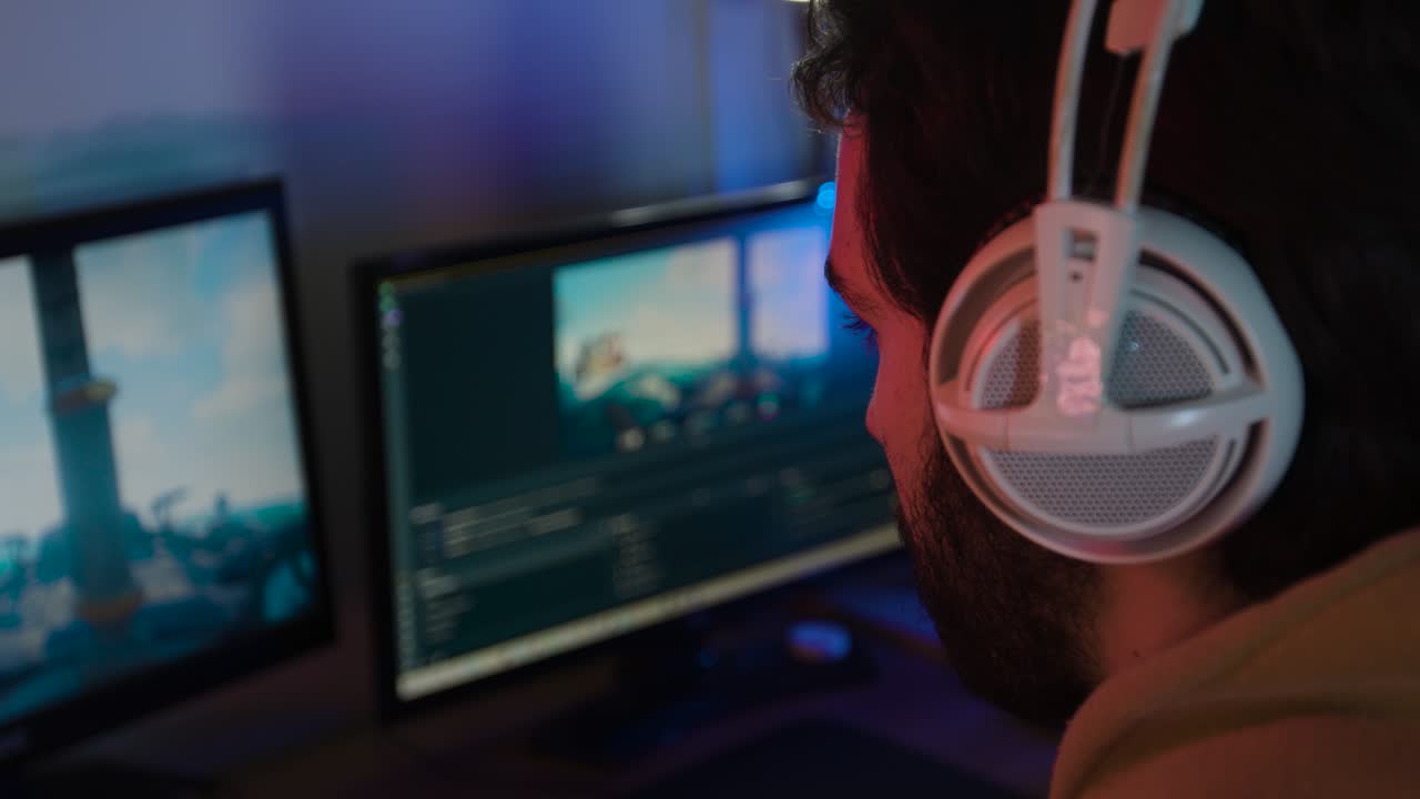 juegos masculinos en una pc que se transmiten por encima del hombro cerca de los auriculares