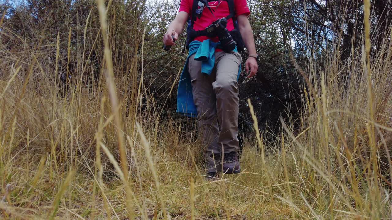 Low-angle static shot of a man hiking on an old Andean Inca trail near Cusco, Peru. Off-the-beaten-path going from Puka Pukara ruins to Inkilltambo archaeological complex